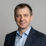 Портрет уверенного российского бизнесмена с дружелюбным взглядом на нейтральном фоне для компании Деньги Плюс