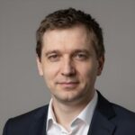 Портрет уверенного российского бизнесмена с дружелюбным взглядом на размытом нейтральном фоне студии